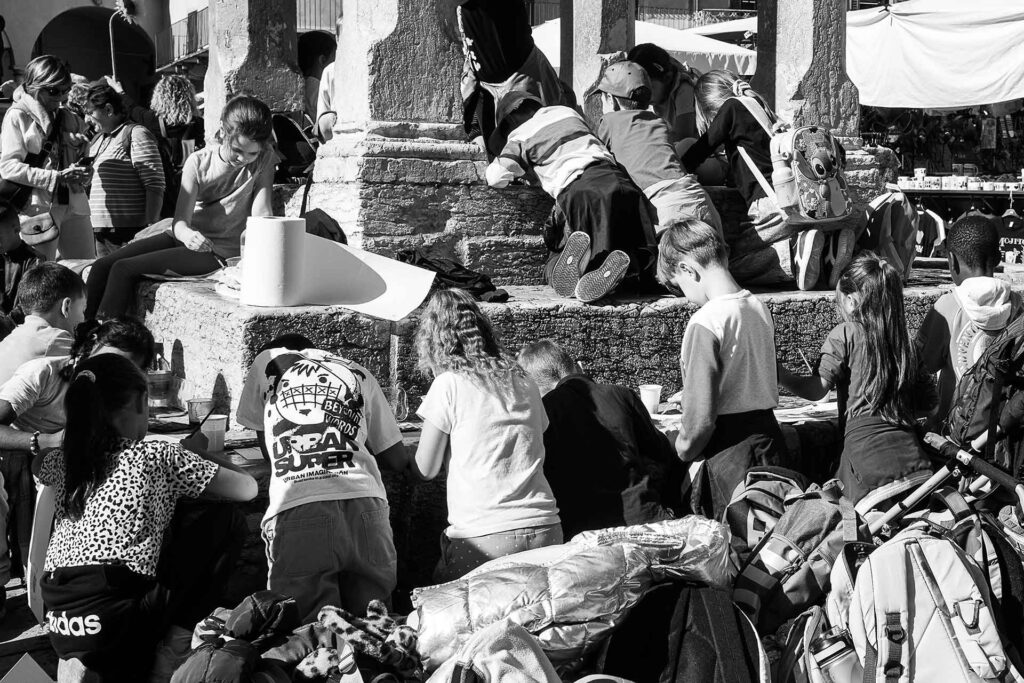 I gradini di un monumento presi d'assalto da una moltitudine di bambini. Street Photography, Black and White.